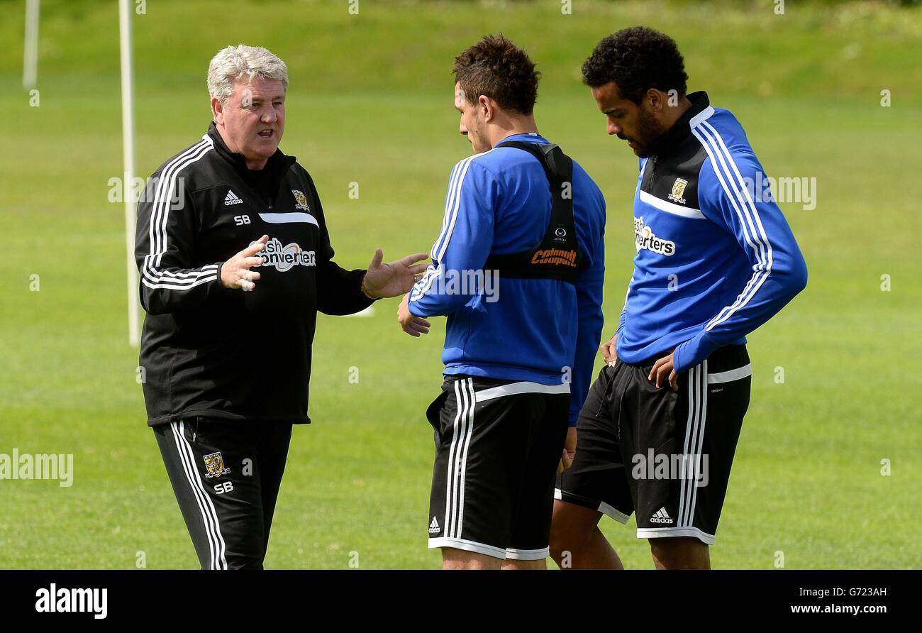 Le directeur de Hull City, Steve Bruce, discute avec Jake Livermore (au centre) et Tom Huddlestone (à droite) lors d'une séance de formation ouverte sur le terrain de formation des équipes à Cottingham, à Hull. Banque D'Images