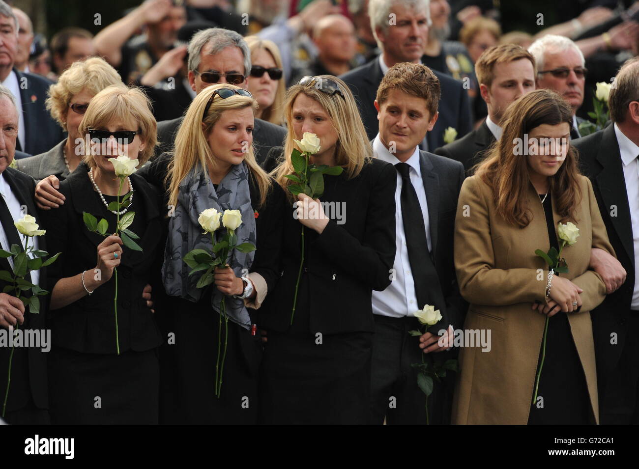 Les bourneurs paient leurs respects alors que les cercueils de cinq militaires tués lors d'un accident d'hélicoptère en Afghanistan passent devant le jardin commémoratif de Carterton, dans l'Oxfordshire. Banque D'Images