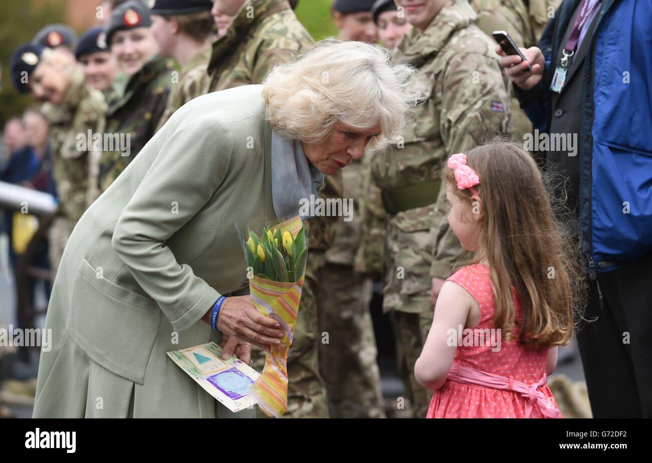 La duchesse de Cornwall est présentée avec une bouée de fleurs par Maisie Kennedy, cinq ans, lors d'une cérémonie de dévouement pour commémorer le déménagement du Groupe de formation des services médicaux de la Défense à DMS Whittington à Whittington Barracks, Lichfield. Banque D'Images