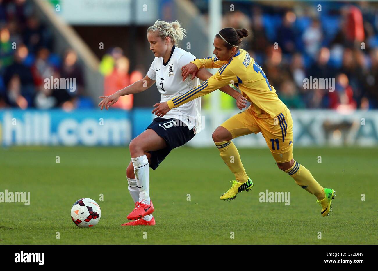 Steph Houghton, en Angleterre, coupe Tetiana Roamenko en Ukraine lors de la coupe du monde féminine FIFA 2015, match de qualification du groupe six au stade Greenhous Meadow, Shrewsbury. Banque D'Images