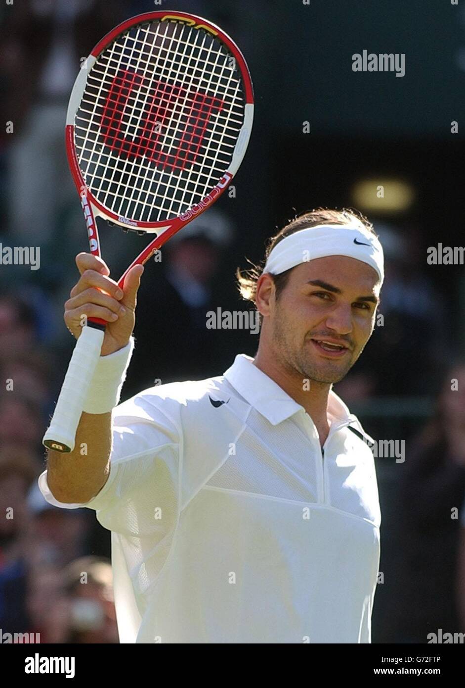 Le champion défenseur Roger Federer élève sa raquette sur le terrain après  avoir battu Alejandro Falla de Columbia aux championnats de tennis de  pelouse à Wimbledon, Londres.Federer a gagné en jeux droits