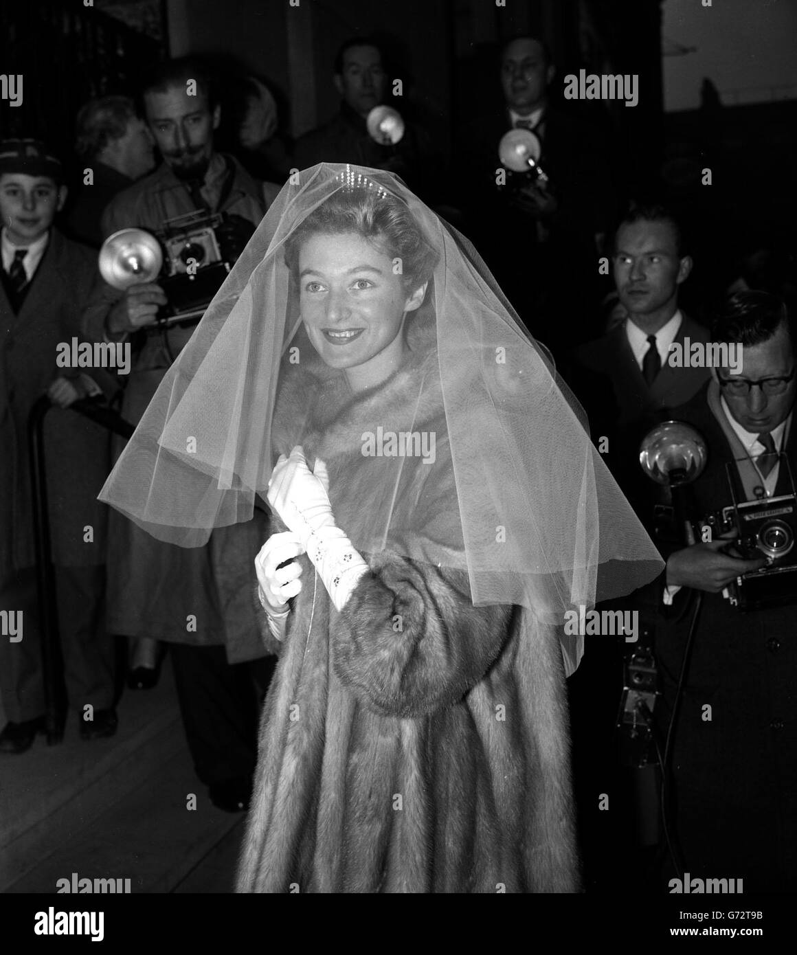 Angela Buxton porte un manteau de vison sur sa robe de mariage alors qu'elle arrive pour son mariage à l'avocat Donald Silk à la synagogue de l'Ouest, Marylebone, Londres. Banque D'Images