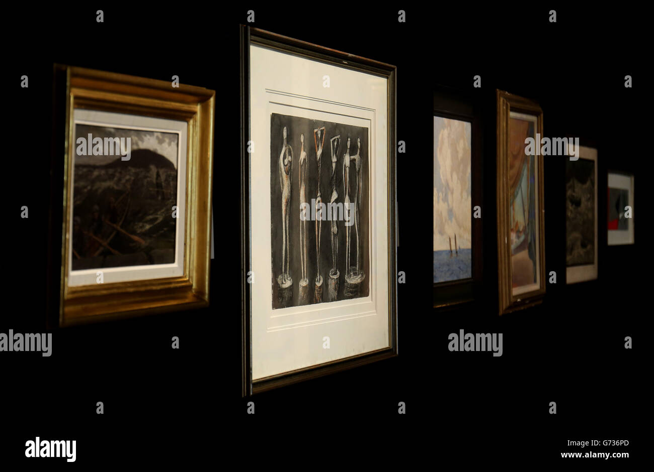 Rebecca Holman, membre du personnel de Bonham, examine les six figures permanentes de Henry Moore qui doivent être vendues dans le cadre de la vente aux enchères d'art britannique et irlandais moderne le 28 mai. Banque D'Images