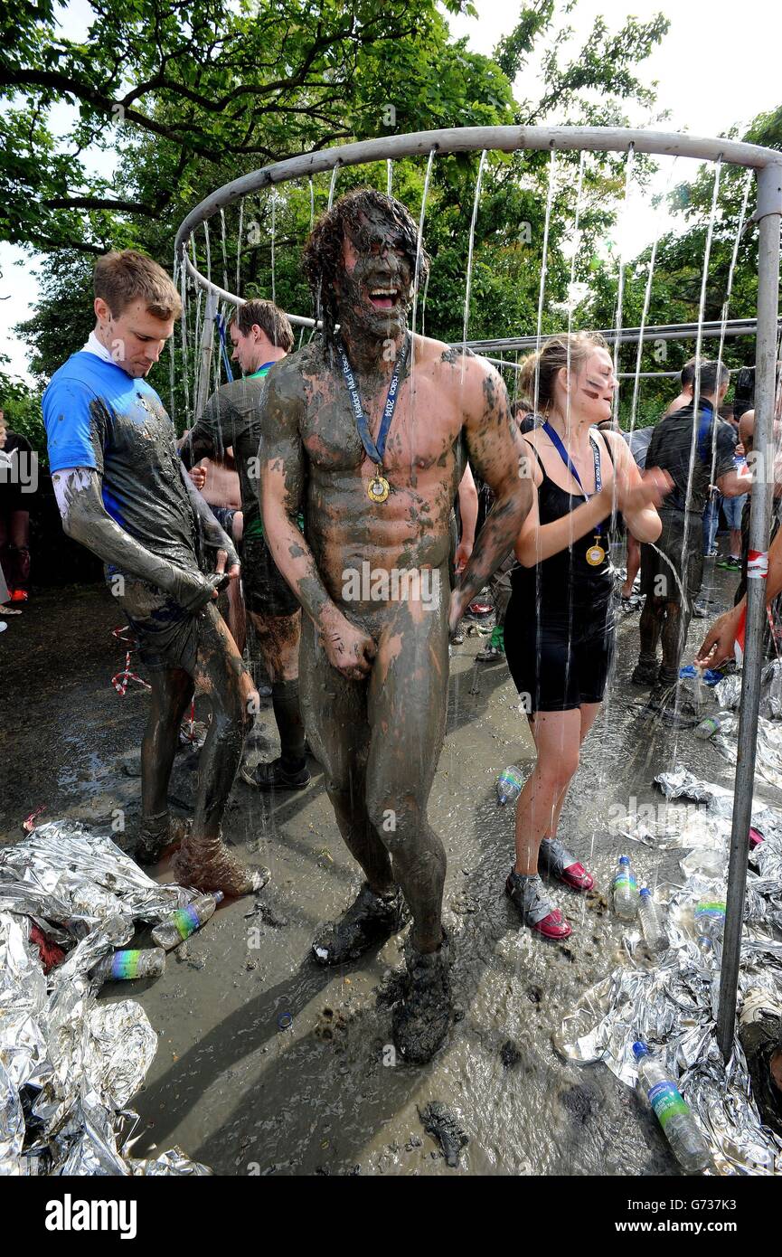 Les concurrents s'éprennent après avoir participé à la course Maldon Mud, un événement caritatif sur la rivière Blackwater à Maldon, dans l'Essex. Banque D'Images