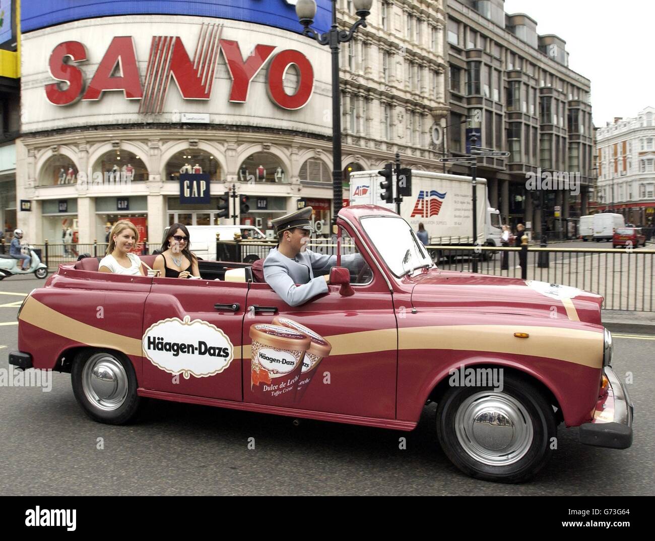 Chauffeur Daniel Bleaney avec Julia Baptista (à gauche) et Rebecca Hurwitz lors du lancement du tout premier taxi convertible du Royaume-Uni, dévoilé par Haagen Dazs Ice Cream pour célébrer deux de leurs saveurs estivales les plus populaires - Dulce de Leche et Strawberry Cheesecake - à Piccadilly Circus, dans le centre de Londres. Banque D'Images