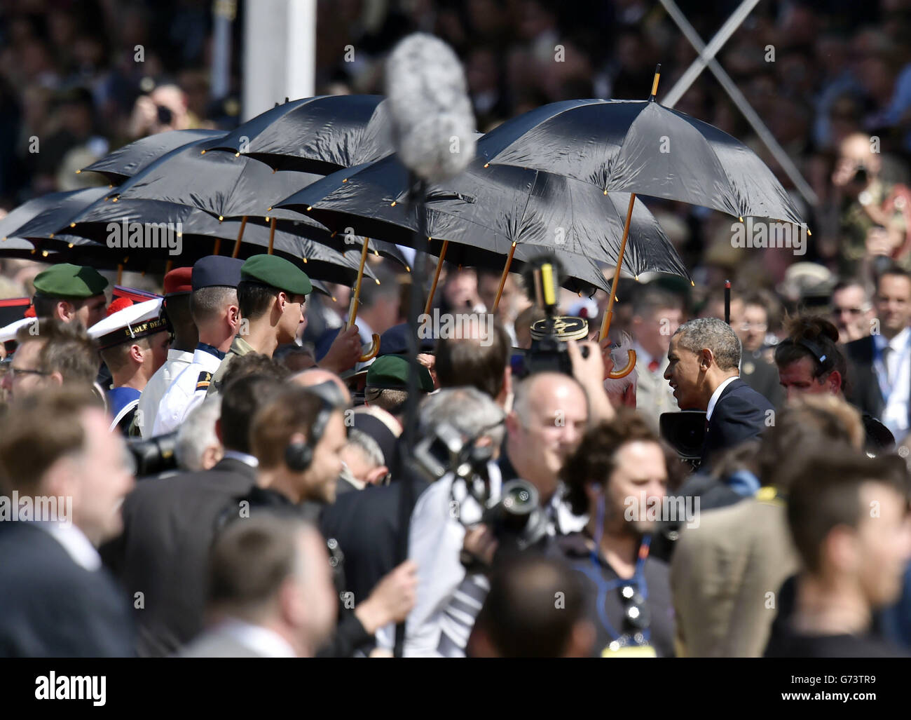 LE président AMÉRICAIN Barak Obama rencontre des anciens combattants, protégés par des parasols du soleil, tandis que lui et d'autres chefs d'État participent à l'événement commémoratif international organisé par le président français François Hollande pour commémorer le 70e anniversaire des Landes de Sword Beach. Banque D'Images