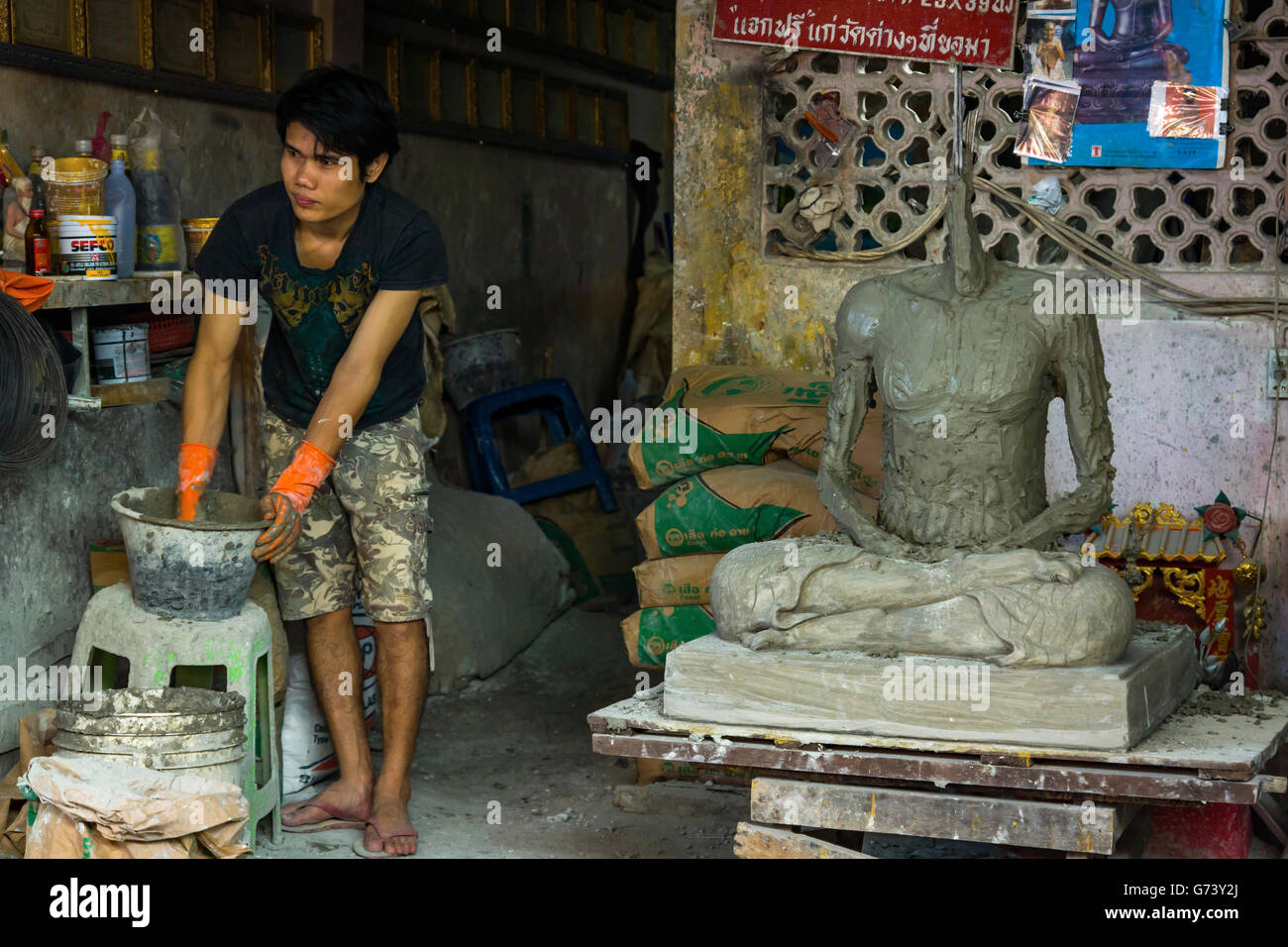 Un homme d'une sculpture statue de Bouddha en utilisant du ciment, Bangkok en Thaïlande. Banque D'Images