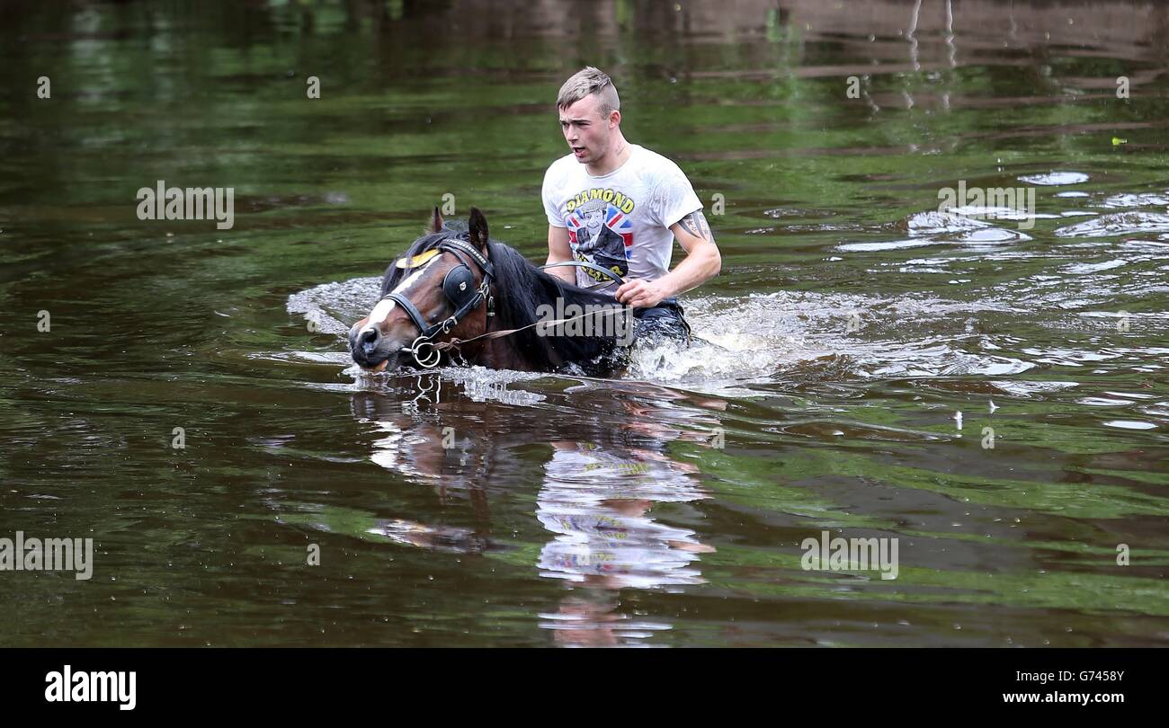 Un membre de la communauté de voyage à cheval dans la rivière Eden au début de la foire du cheval Appleby, le rassemblement annuel des gitans et des voyageurs à Appleby, Cumbria. Banque D'Images