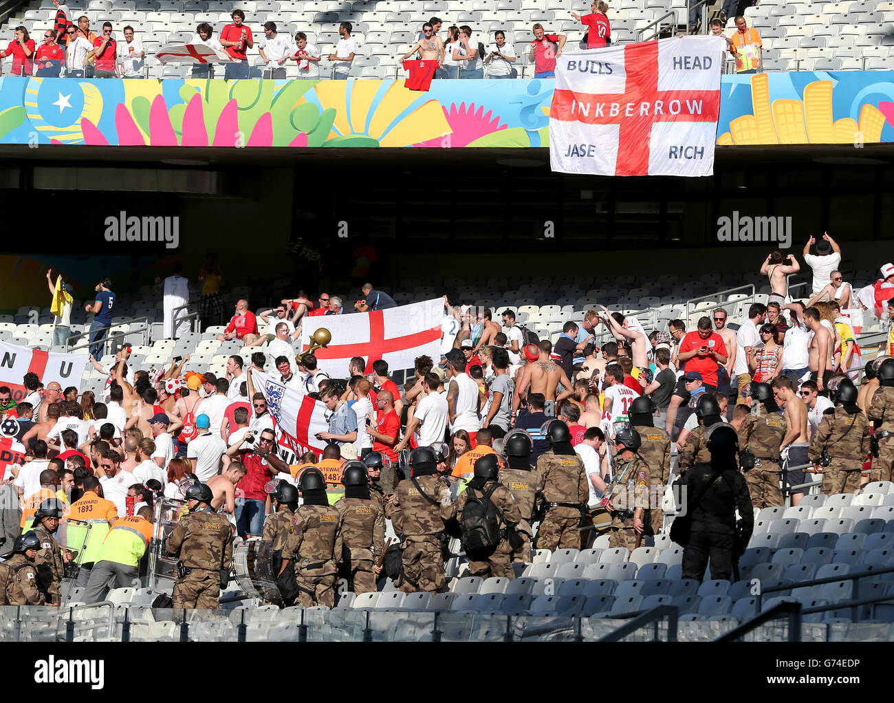 La police militaire garde un œil vigilant sur les fans d'Angleterre après le coup de sifflet final lors de la coupe du monde de la FIFA, match du Groupe D à l'Estadio Mineirao, Belo Horizonte, Brésil. Banque D'Images
