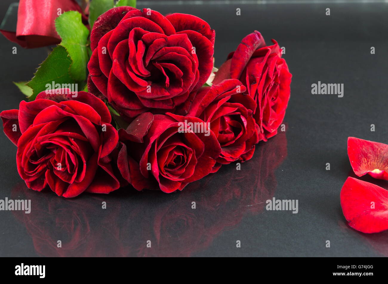 Bouquet de roses rouges avec ruban sur table dark mirror Banque D'Images