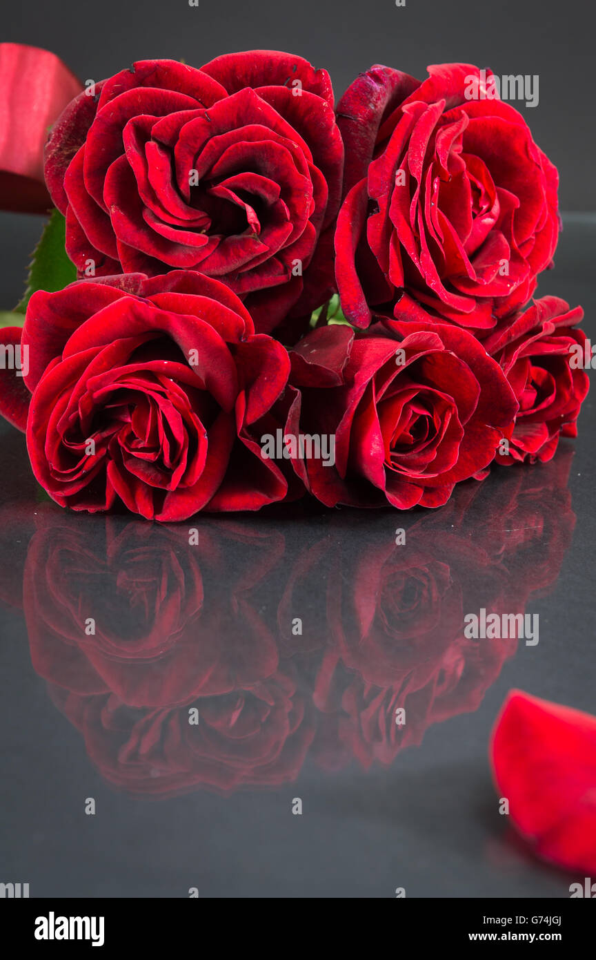 Bouquet de roses rouges avec ruban sur table dark mirror Banque D'Images