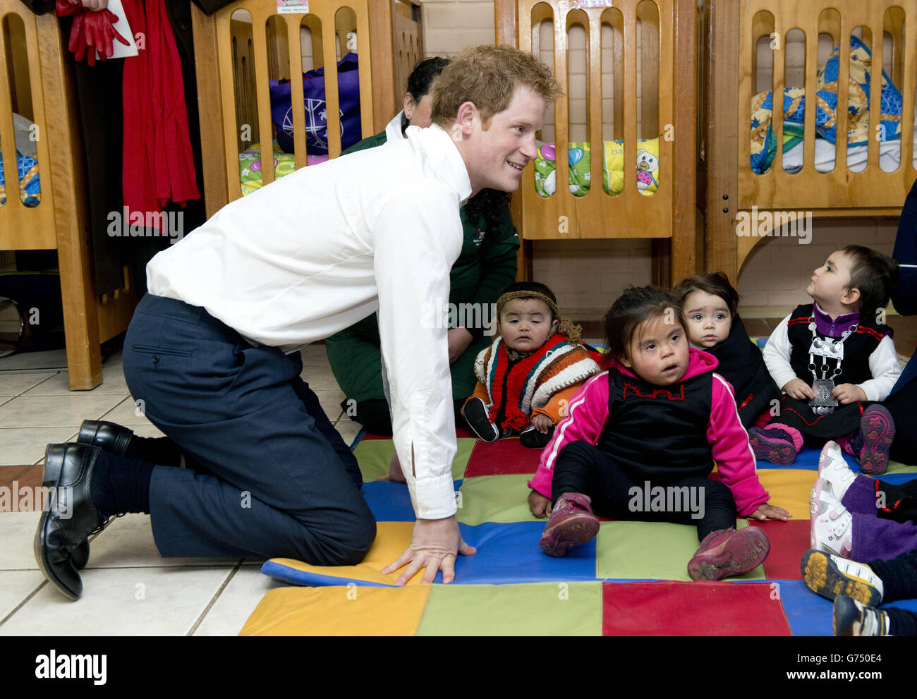 Le Prince Harry se joint à des jeux qui se jouent lors d'une visite d'une maternelle pour les enfants autochtones à Santiago, au Chili. APPUYEZ SUR ASSOCIATION photo. Date de la photo: Vendredi 27 juin 2014. Voir l'histoire de l'AP, ROYAL Harry. Le crédit photo doit être lu : Dan Charity/The Sun/PA Wire Banque D'Images