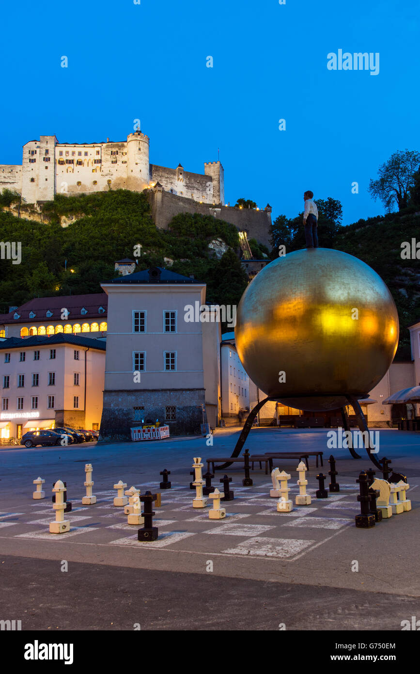 Vue nocturne de la place Kapitelplatz avec ballon d or Sphaera nommé monument créé par Stephan Balkenhol et Château de Hohensalzburg Banque D'Images