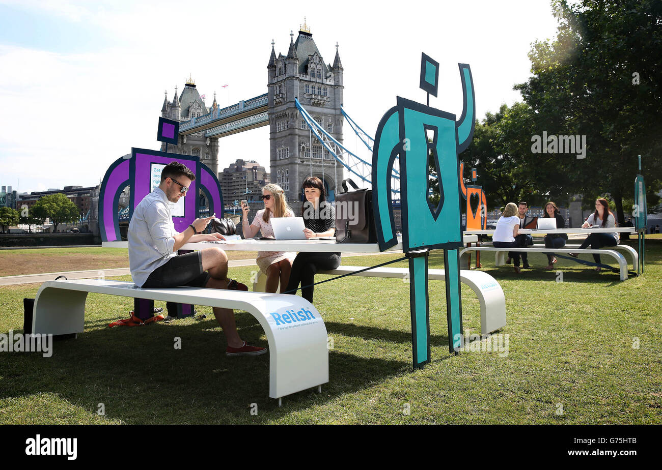 Les gens utilisent les hotspots wifi pop-up gratuits de Potters Fields Park à Londres qui ont été installés par relish, un nouveau fournisseur de réseau sans fil 4G pour le centre de Londres. Banque D'Images