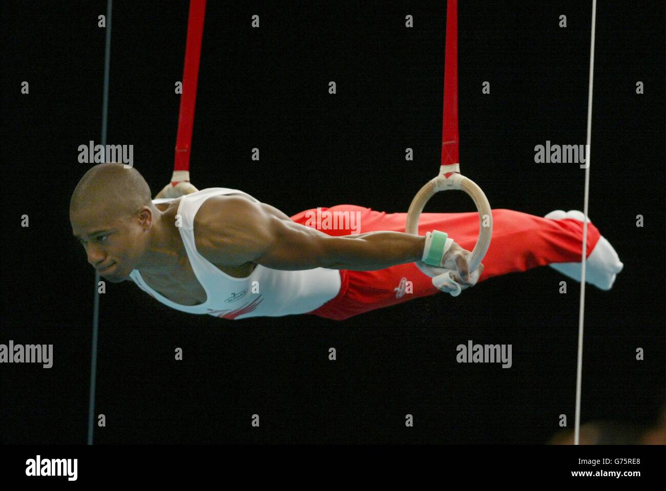 Kanukai Jackson d'Angleterre sur les anneaux pendant la finale de gymnastique individuelle des hommes aux Jeux du Commonwealth 2002 au GMEX, Manchester. Jackson a gagné l'or. Banque D'Images