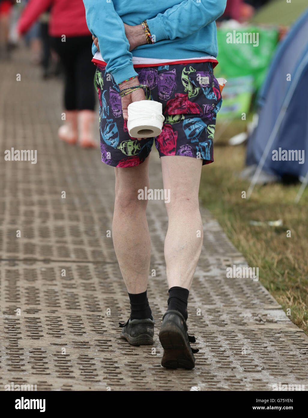 Un gardien de festival transportant un rouleau de toilettes au Glastonbury Festival, à la ferme de la digne dans le Somerset. Banque D'Images