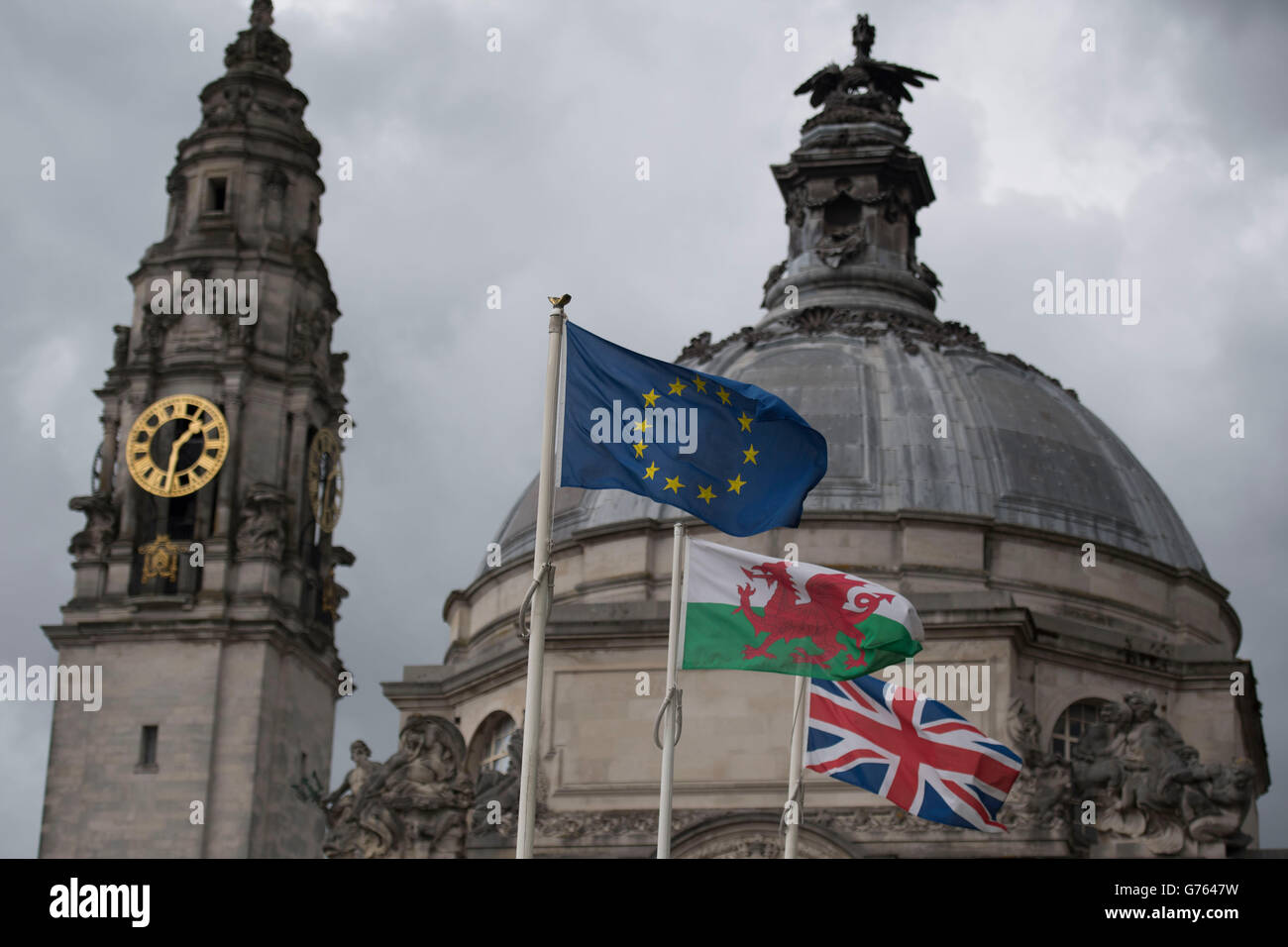 Un drapeau gallois au Pays de Galles entre une Union Jack et un drapeau de l'Union européenne. Banque D'Images