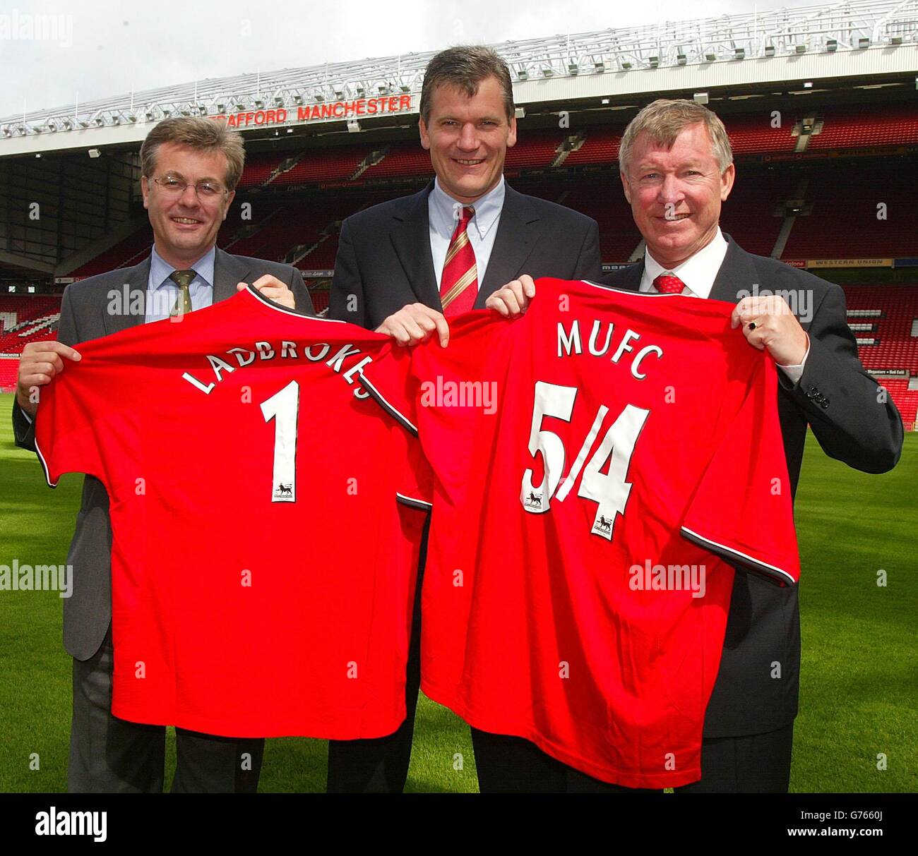 Chris Bell, directeur général du groupe, David Gill (au centre), et Sir Alex Ferguson, directeur général de Manchester United, tiennent des maillots Manchester United lors du lancement de Labrokes en tant que partenaire officiel de Manchester United à Old Trafford, Manchester. Banque D'Images