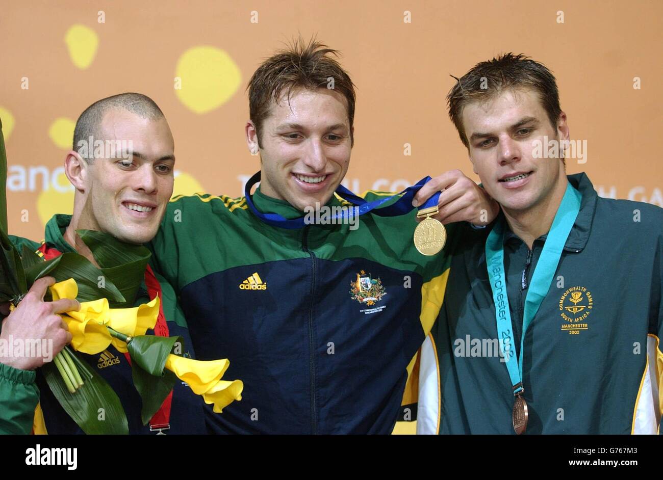 Ian Thorpe (au centre), de l'Australie, remporte l'or avec l'argent Ashley Callus (à gauche) de l'Australie et le bronze Ryk Neethling de l'Afrique du Sud dans les finales Freestyle de 100 m pour hommes au centre aquatique de Manchester. Banque D'Images