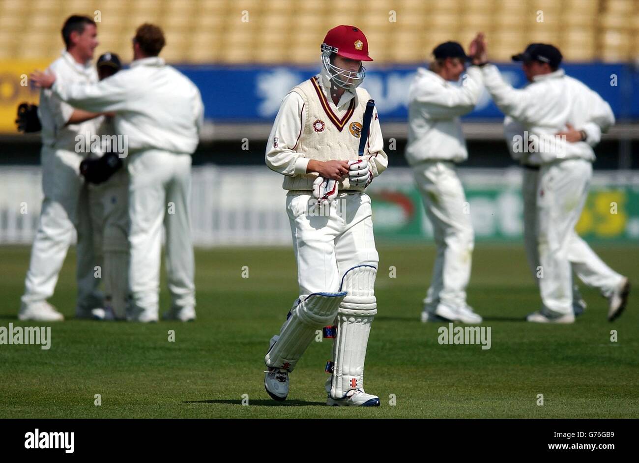 Les joueurs de Warwickshire célèbrent en arrière-plan après que Russell Warren (au centre) de Northamptonshire a été pris par Ian Bell du bowling d'Ashley Giles pour 3 courses pendant leur match de la coupe Benson and Hedges à Edgbaston, Birmingham.Northamptonshire a fait 226. Banque D'Images