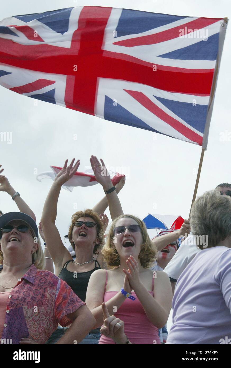 , PAS D'UTILISATION COMMERCIALE. Les fans de tennis de « Henman Hill » applaudissent Tim Henman, la star britannique des singles hommes, en action contre Wayne Ferreira, originaire d'Afrique du Sud, au centre court de Wimbledon. * des milliers de supporters se sont entassés dans le club de tennis All England Lawn, avec beaucoup de regarder sur un écran géant de télévision de la colline. Le gagnant passe aux quarts de finale. Banque D'Images