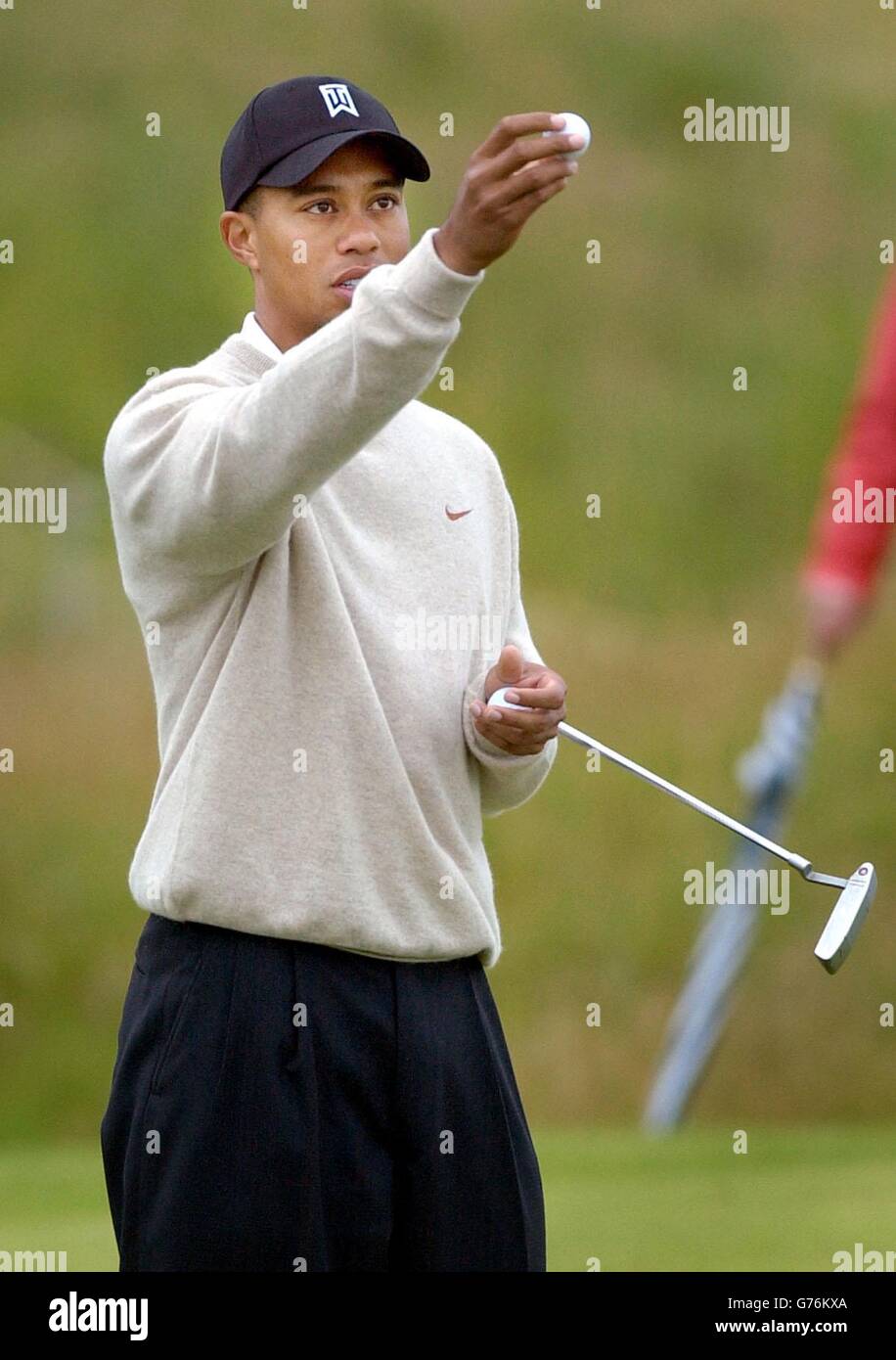 Tiger Woods inspecte son ballon lors de la deuxième journée d'entraînement pour le championnat de golf ouvert à Muirfield en Écosse. Banque D'Images