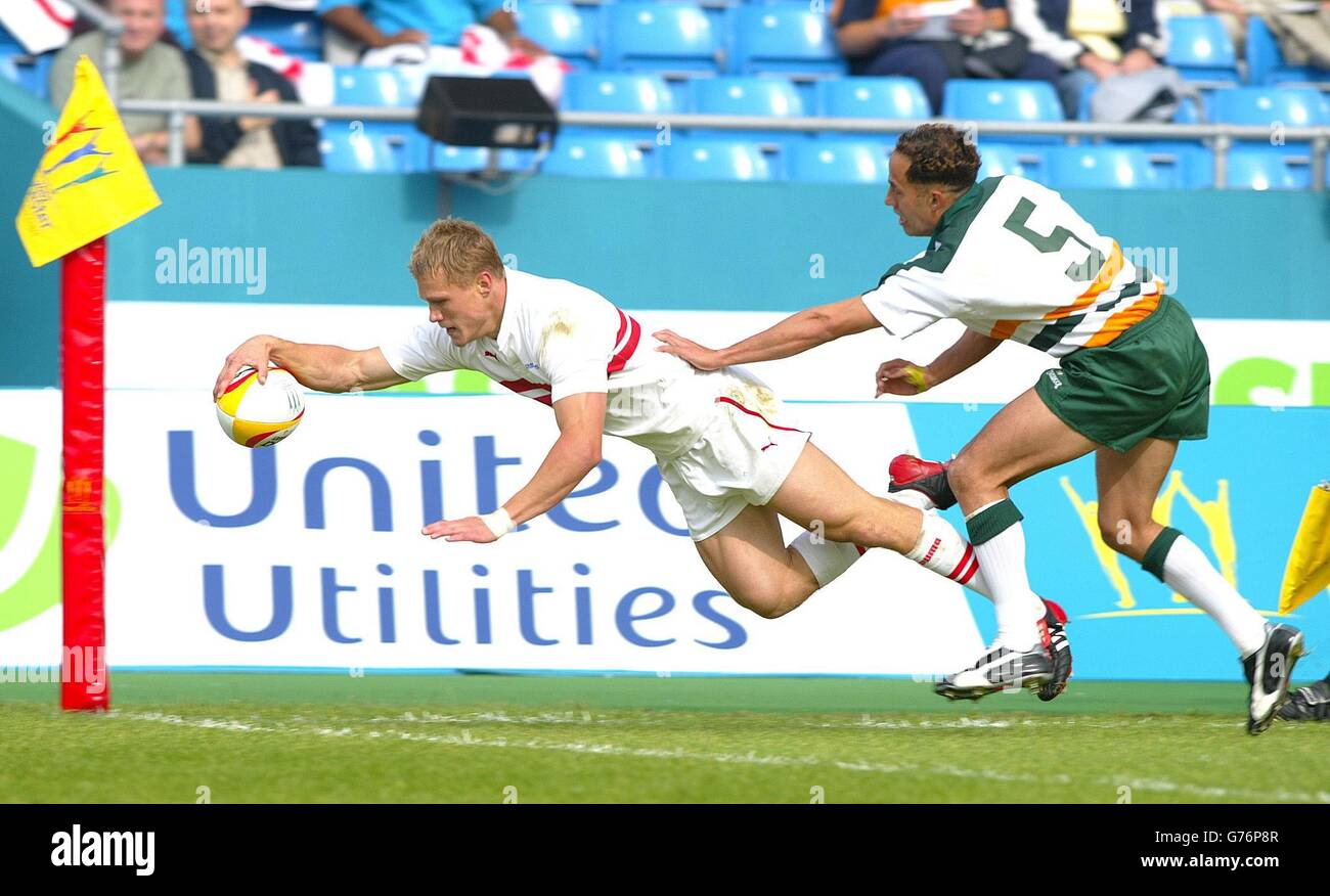 Josh Lewsey, de l'Angleterre, va au-delà de la ligne pour un essai contre Darren Robinson, des îles Cook, pendant les Jeux du Commonwealth, le rugby de la Mens 7, au stade de la ville de Manchester. Banque D'Images