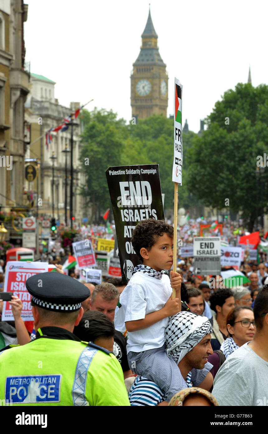 Un garçon tient un écriteau alors qu'il est assis sur les épaules de son père, alors que des milliers de manifestants se rassemblent à Trafalgar Square, dans le centre de Londres, pour appeler à la fin de l'action militaire israélienne à Gaza et à la « justice et liberté » pour la Palestine. Banque D'Images