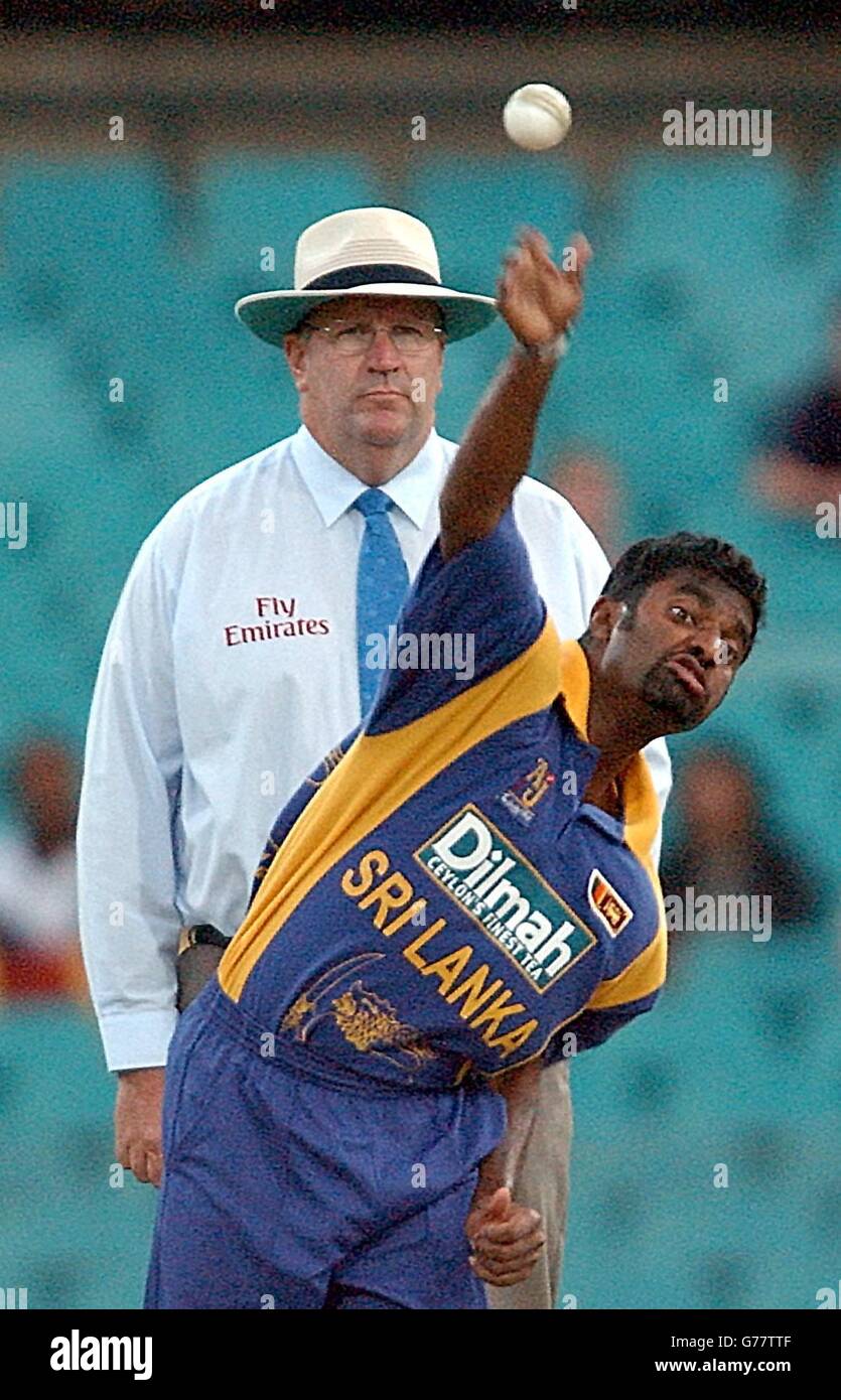 Murali Muralitharan, le moulinet sri lankais, a été suivi de près par le juge-arbitre Darrell Hair, lors du match international One Day au Sydney Cricket Ground, Sydney, Australie. 10/11/04: Muttiah Muralitharan, un mouilleur sri-lankais qui a effectivement reçu le tout-clair de faire son 'doosra' dans le cricket d'essai après qu'un panel du Conseil international de cricket a décidé que tous les joueurs peuvent plier leurs armes en livraison. Le spinner Murali, qui a toujours maintenu qu'il ne peut pas redresser complètement son bras, a fait l'objet d'un examen de plus en plus attentif cette année quand l'arbitre de match de la CPI Chris Broad a signalé son erreur "un au monde" Banque D'Images