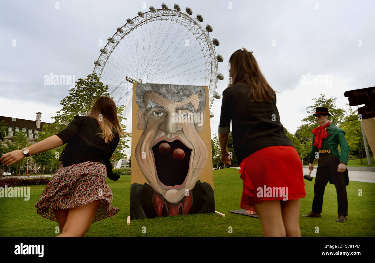 Stephanie Francis (à gauche) et Tansy Ratcliffe-James (à droite) jouent le jeu « Jeremy Clarkson Big Mouth » lors d'un appel photo pour le spectacle latéral Carnivale de London Dungeon à Jubilee Gardens, Londres. Banque D'Images