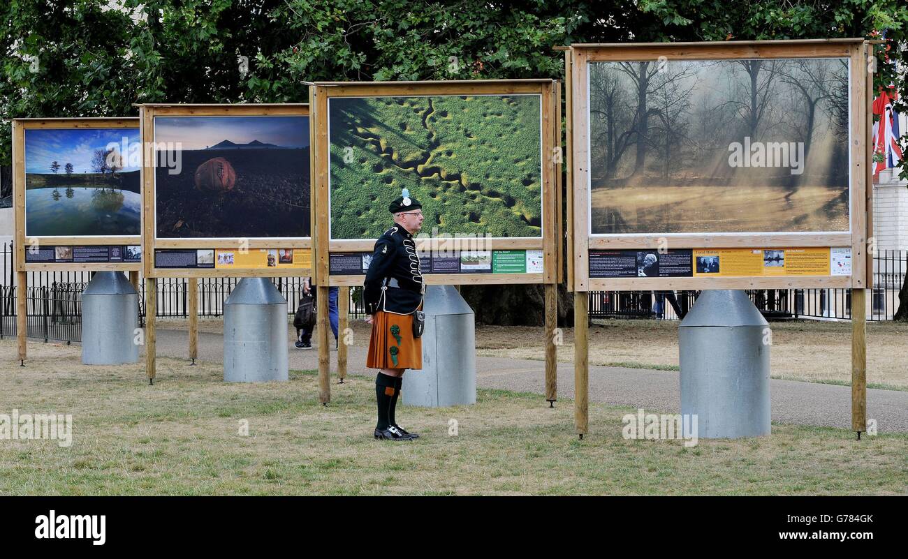 Terry Goodman, joueur à la régimentaire Pipe Association of the London Irish Regiment, regarde un aperçu de la galerie de rue publique Fields of Battle, Lands of Peace de la Royal British Legion, dans le centre de St James's Park, Londres, une série de photographies d'aujourd'hui, par le photographe Michael St.Maur Sheil, Des champs de bataille de la première Guerre mondiale marquant le centenaire du début de la première Guerre mondiale. Banque D'Images