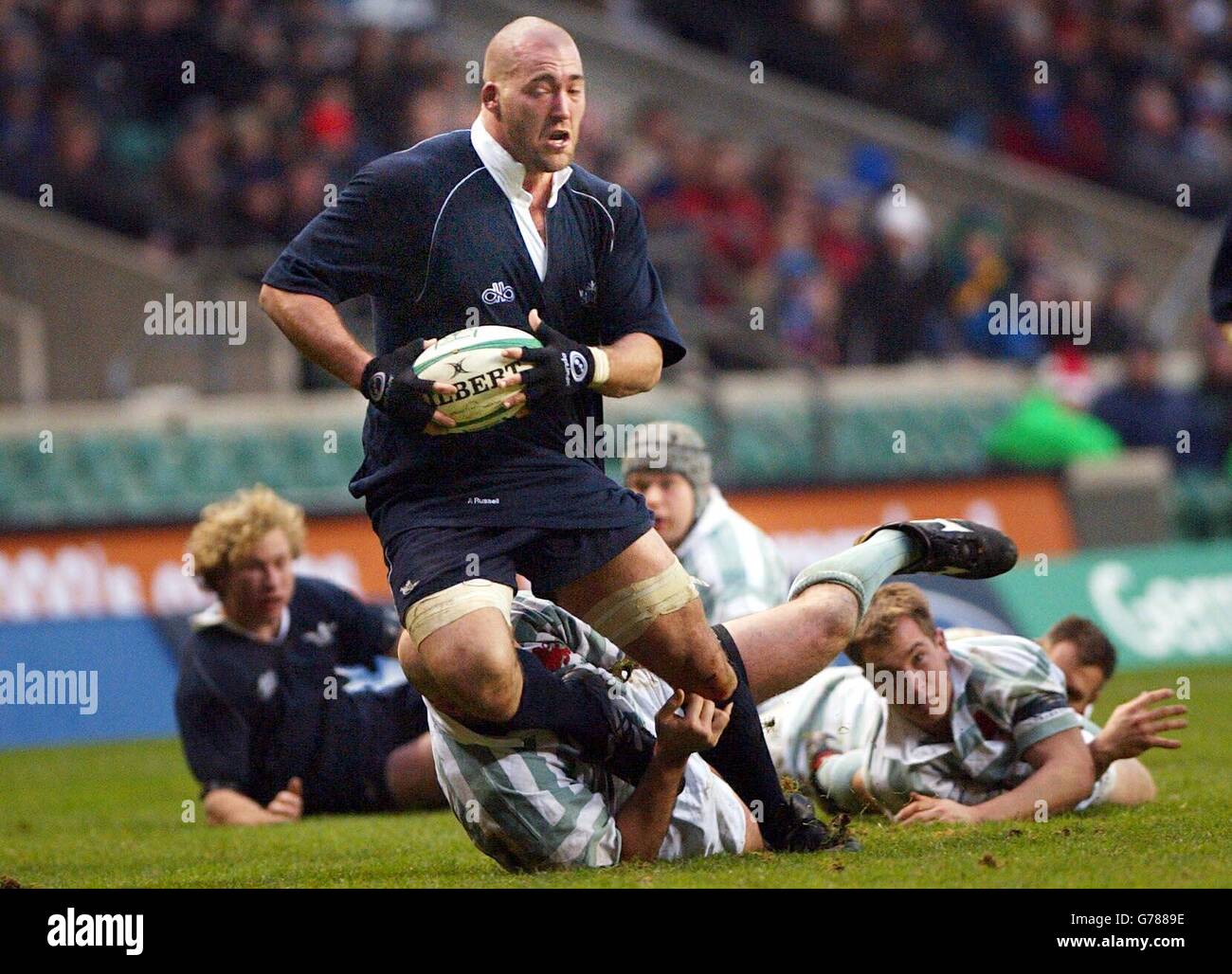 Adam Russell d'Oxford, de Washington DC, aux États-Unis, laisse un sentier de joueurs dans son sillage, lors du match annuel de Varsity. Oxford perd à Cambridge 15-13 à Twickenham, Londres. Banque D'Images