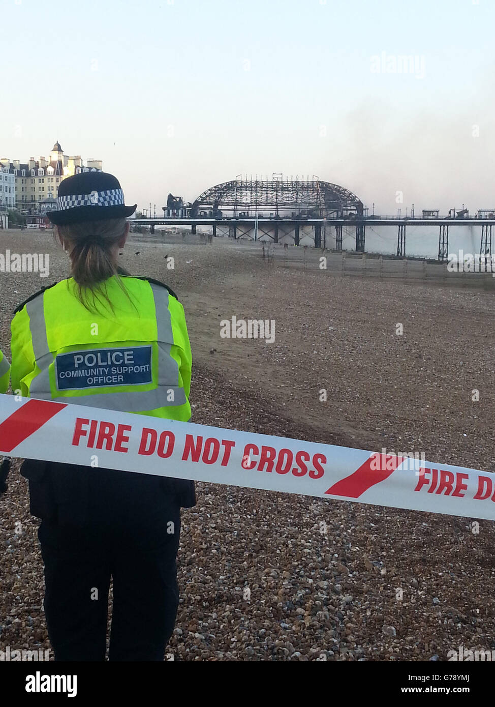 Un agent de police à Eastbourne Pier où un incendie dévastateur a déchiré à travers la structure de grade II, le feu aurait commencé dans le revêtement mural. Banque D'Images