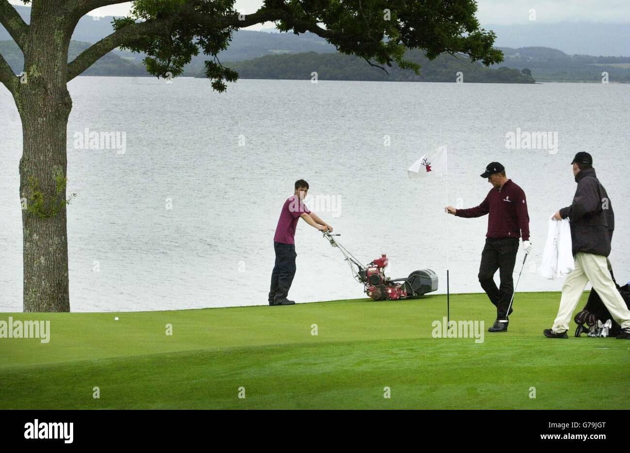 Le gardien de green Ian Craig coupe l'herbe sur le sixième trou au club de golf Loch Lomond près de Balloch en préparation pour le championnat de golf écossais ouvert qui commence sur le parcours jeudi. Banque D'Images