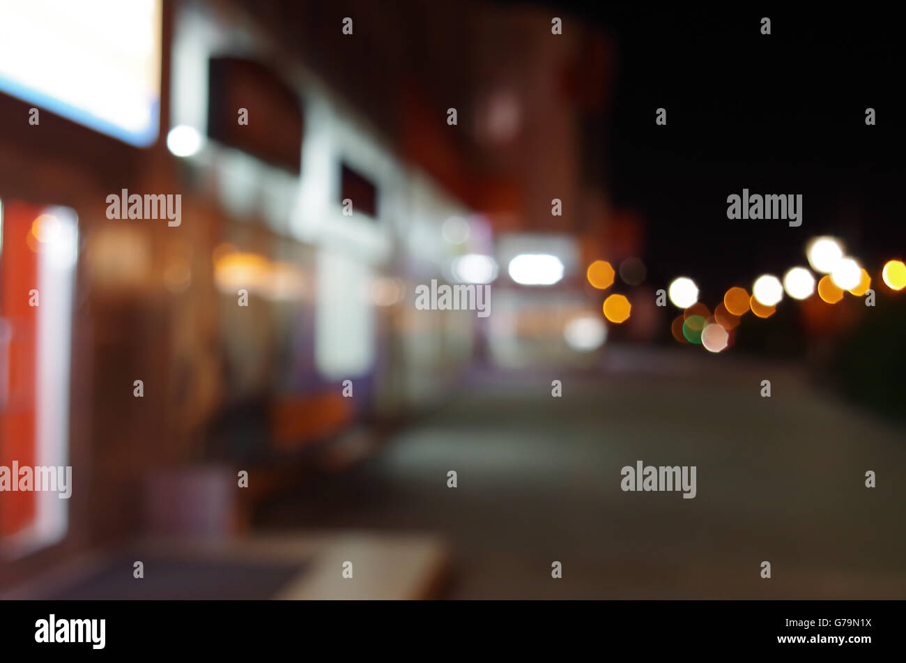 Scène urbaine de nuit avec un éclairage diffus shop windows et lanternes dans la rue pour l'utiliser comme arrière-plan. Banque D'Images