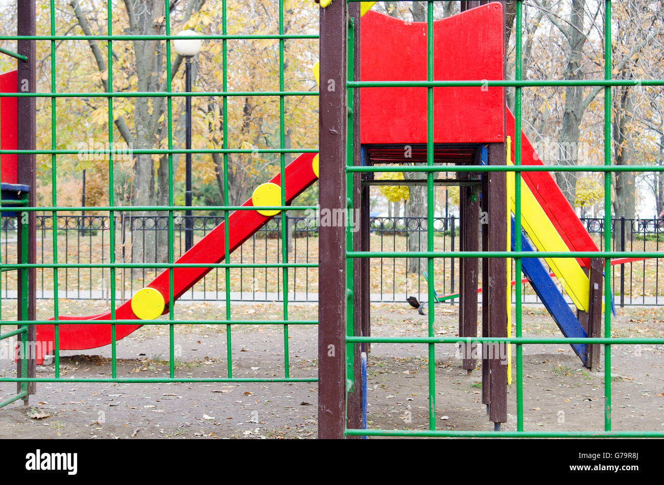 Vide aire de jeux pour enfants et d'une diapositive dans le parc dans le contexte d'arbre en automne avec les feuilles mortes. Selective focus wit Banque D'Images