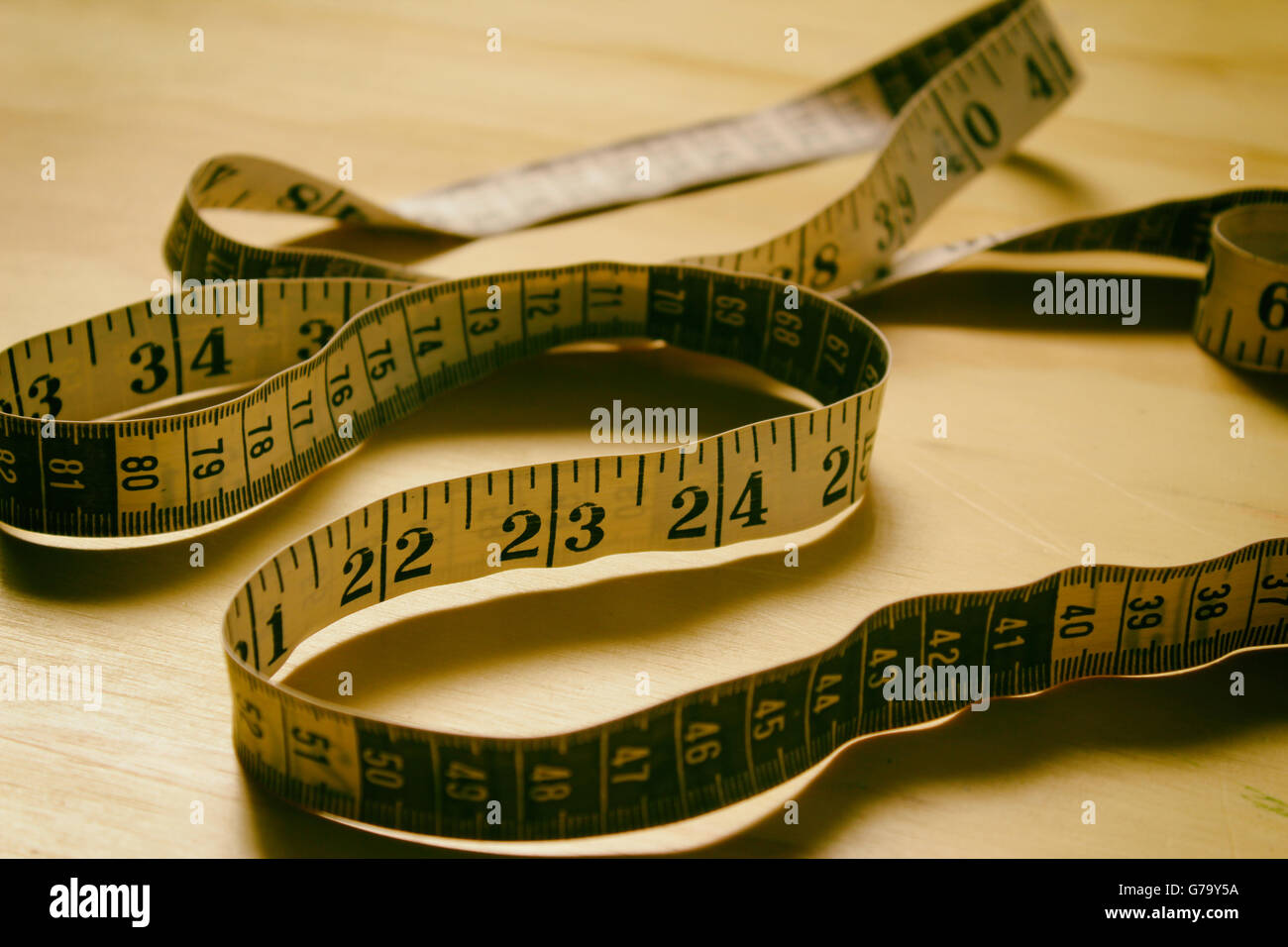 Photographie d'un mince rétro ruban à mesurer sur une table en bois Banque D'Images