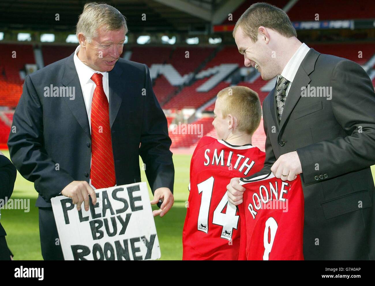 Joe Ruane, fan de Manchester United, 11 ans, partage une blague avec New Manchester United en signant Wayne Rooney et le directeur Sir Alex Ferguson lors d'une conférence de presse au Old Trafford Ground de Manchester United, à Manchester.L'attaquant britannique de 18 ans a terminé son déménagement à United d'Everton dans un marché potentiellement d'une valeur de 27 millions au club de Merseyside juste plus de quatre heures avant la fermeture de la fenêtre de transfert hier. Banque D'Images