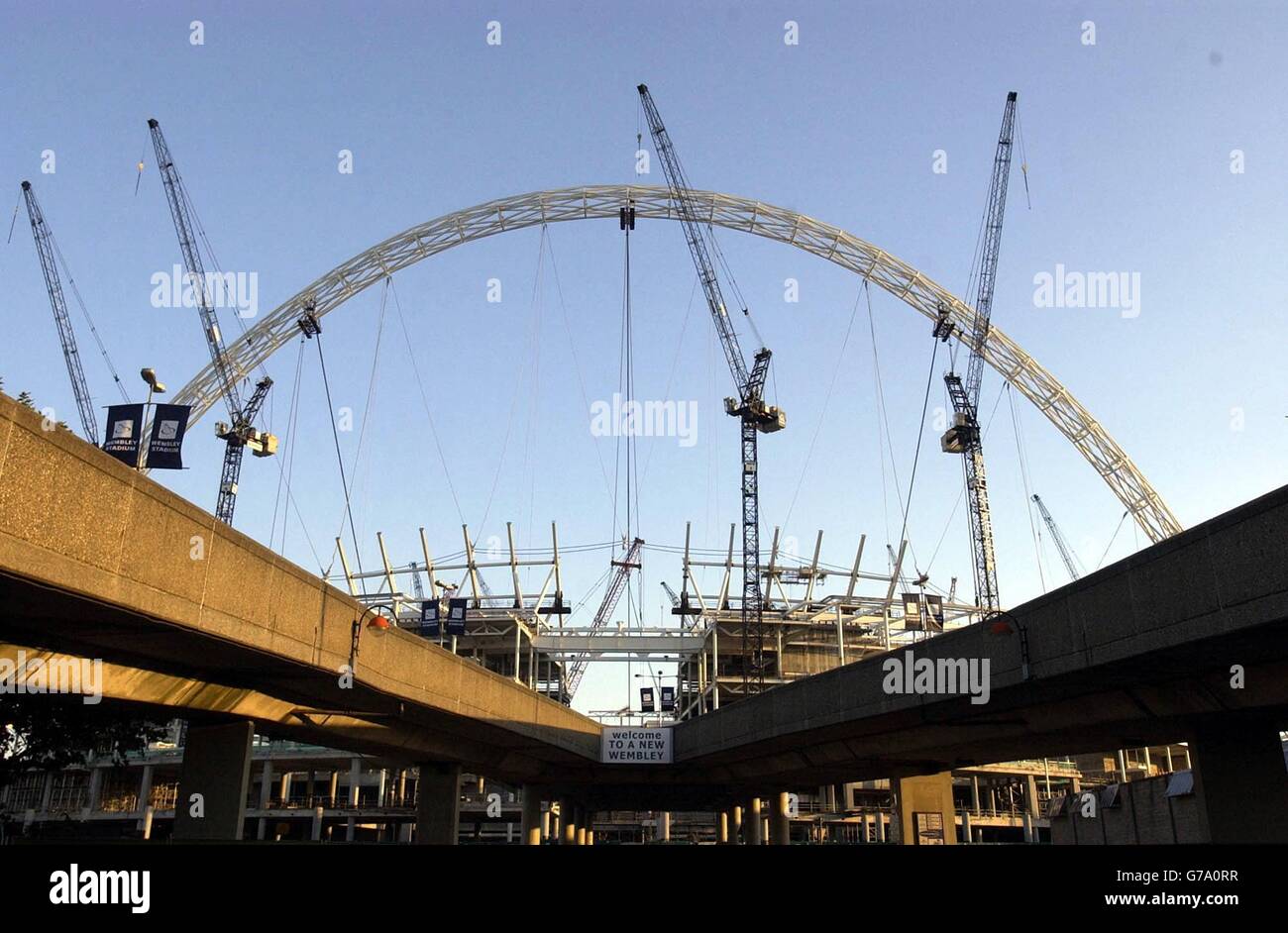 Une vue générale de l'arche ombratée par des grues de construction, au nouveau complexe Wembley Stadium dans le nord-ouest de Londres. Le projet qui est actuellement en proie à des problèmes après des litiges contractuels, doit accueillir une "cérémonie de tête" ce soir. Banque D'Images