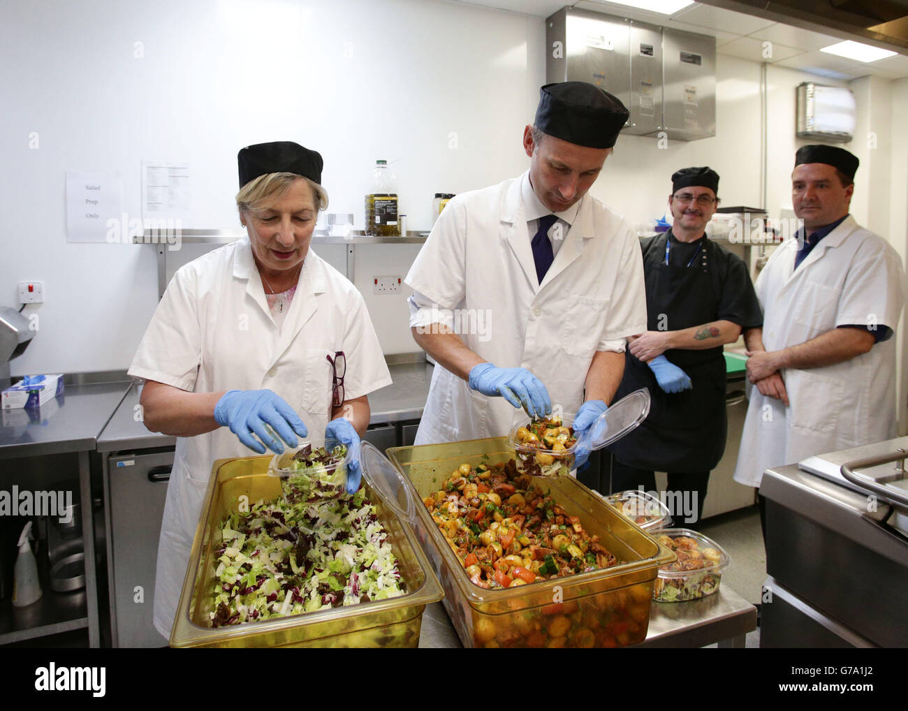 Jeremy Hunt, secrétaire à la Santé, et Dianne Jeffrey, présidente d'Age UK, préparent de la nourriture dans la cuisine de l'hôpital lors d'une visite au Royal Marsden à Chelsea, Londres. La purée de pommes de terre et les légumes soggy seront devenus une chose du passé pour les patients et le personnel de l'hôpital en vertu de nouvelles règles visant à bannir les aliments inacceptables au NHS. Banque D'Images
