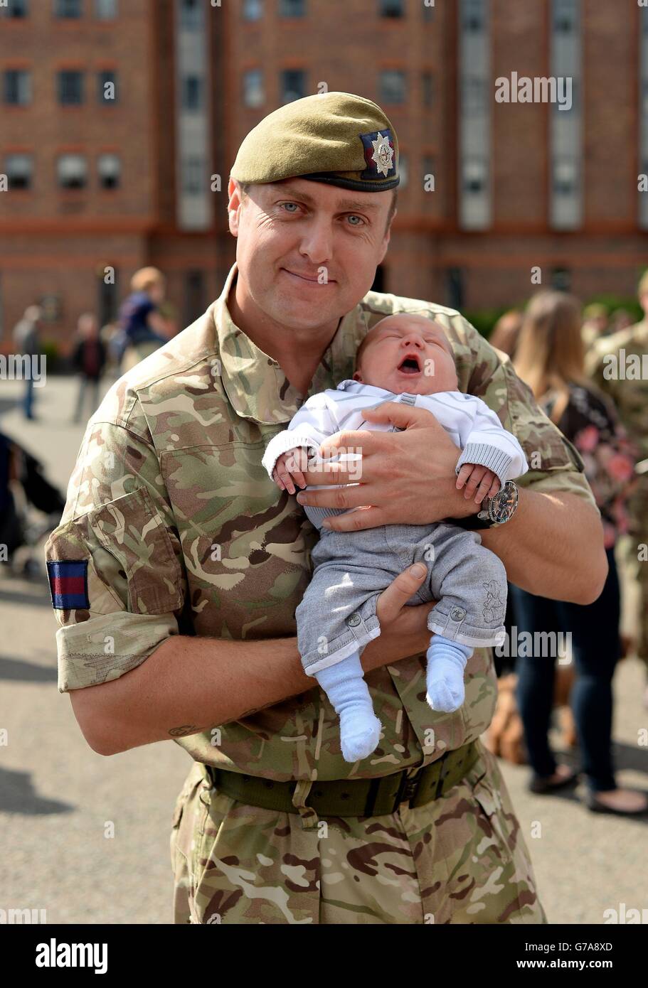 Le sergent-major de compagnie (CSM) Glen Goldthorpe, du 1er Bataillon Coldstream Guards, tient son fils Harry dans ses bras, né il y a 4 jours, juste après son retour d'un déploiement de six mois en Afghanistan. Banque D'Images
