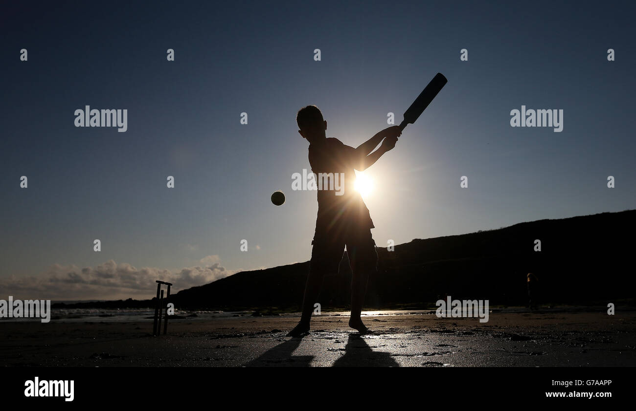 Beach Cricket, stock. Un garçon joue au cricket de plage dans les Cornouailles Banque D'Images