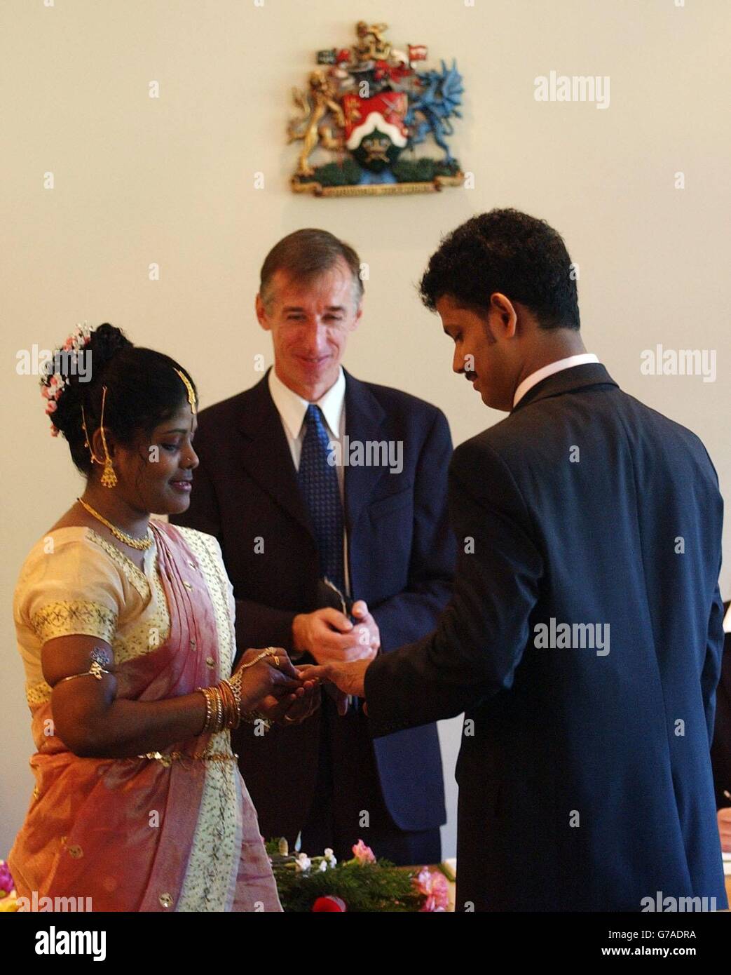 Sivaruban Sivasubramaniam (à droite) et Sripriya Ramamoorthy échangent des anneaux lors de leur mariage observé par le registraire John Perkins, à la mairie de Brant, qui est devenue le premier mariage à avoir lieu un dimanche au Royaume-Uni. On espère que le service sera d'une importance particulière pour les diverses communautés de Brant, en particulier pour celles dont les traditions culturelles signifient qu'elles souhaitent se marier un dimanche. Banque D'Images