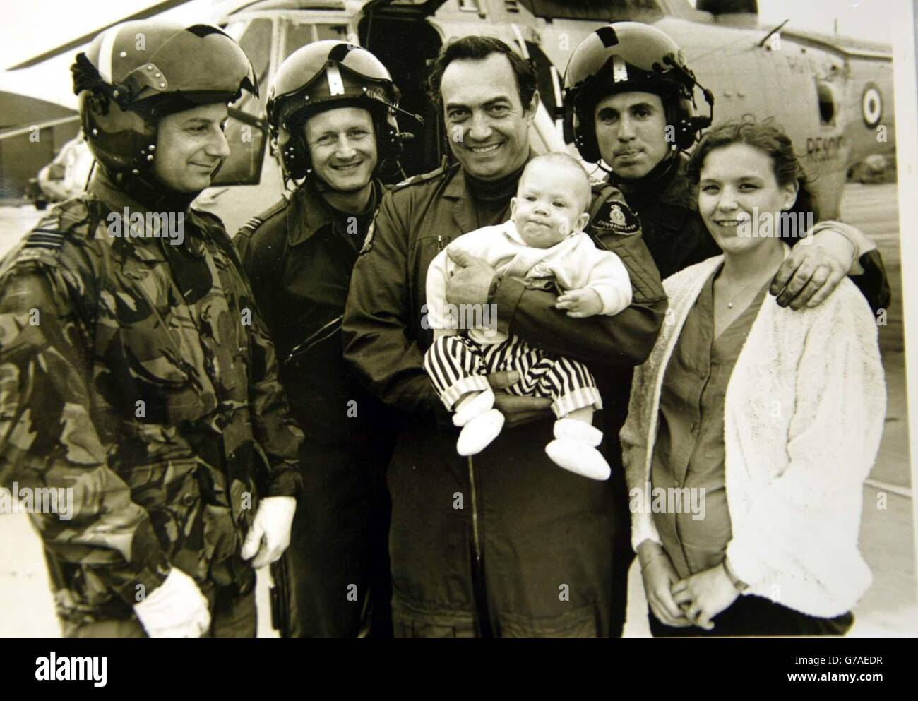 Base aérienne de RAF Kinloss, Morayshire, Écosse, RAF Rescue Winchman, centre Bob Pountney tenant le bébé Sam Harcus après qu'il ait sauvé sa vie en mission il y a 16 ans. Photo avec d'autres membres de l'équipage et la mère de Sams, Gillian Harcus. Banque D'Images