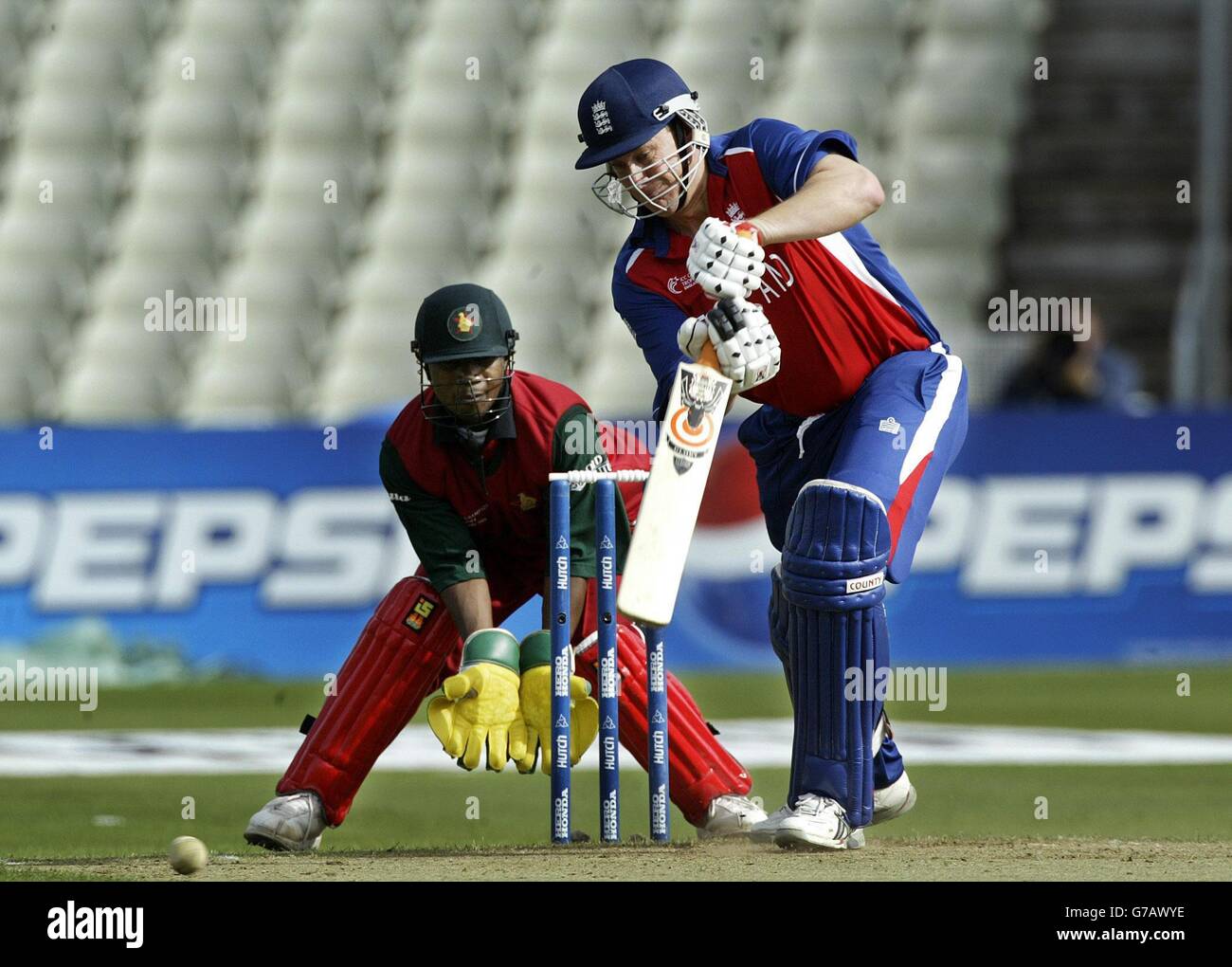 USAGE ÉDITORIAL EXCLUSIF, PAS D'UTILISATION DE TÉLÉPHONE MOBILE.Ashley Giles, en Angleterre, dirige la balle surveillée par le gardien de cricket et capitaine du Zimbabwe, Tatenda Taibu, lors du premier match du trophée des champions de l'ICC à Edgbaston. Banque D'Images