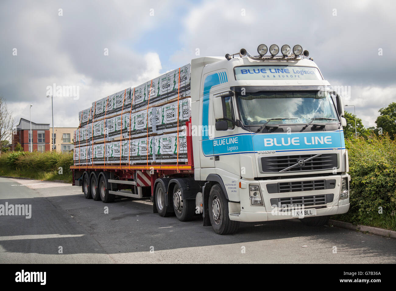 Blue Line Logistics livrant du bois de construction emballé et raboté BSW (bois easi) ; unité de tracteur Volvo à lancettes avec matériaux de construction à faible charge à Kirkham, Lancashire, Royaume-Uni. Banque D'Images