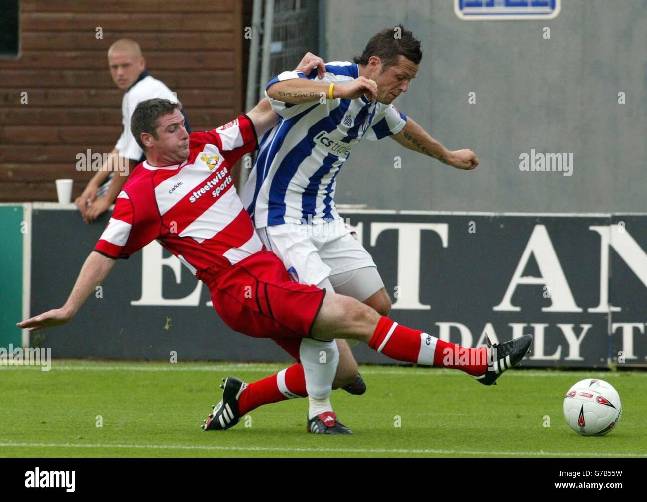 Doncaster Rovers (rouge) Sam Stockley lance un match au John Doolan de Colchester United lors de leur match de la Coca-Cola League One au stade Layer Road de Colchester. PAS D'UTILISATION DU SITE WEB DU CLUB OFFICIEUX. Banque D'Images