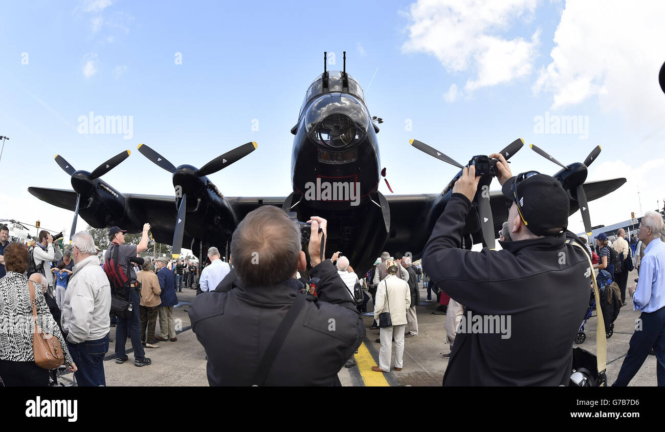 Les gens prennent des photos du bombardier Lancaster, l'un des deux seuls au monde en vol, à l'aéroport de Durham Tees Valley, à Darlington, lorsqu'il visite le pays. Banque D'Images