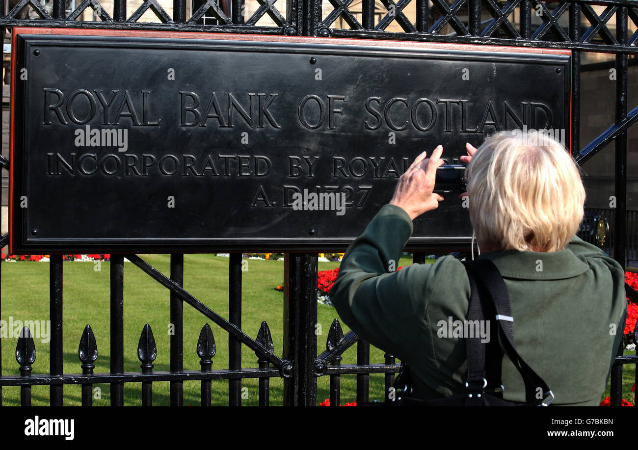 Une femme prend une photo du panneau de la Royal Bank of Scotland (RBS) au siège social écossais de St Andrew Square,Édimbourg, en tant que Premier ministre et dirigeant du SNP, Alex Salmond, a déclaré qu'il y aurait une « enquête inévitable » sur les allégations selon lesquelles le Trésor aurait divulgué des informations « sensibles au marché » sur la proposition de RBS de s'enregistrer en Angleterre si l'Écosse votait pour l'indépendance. Banque D'Images