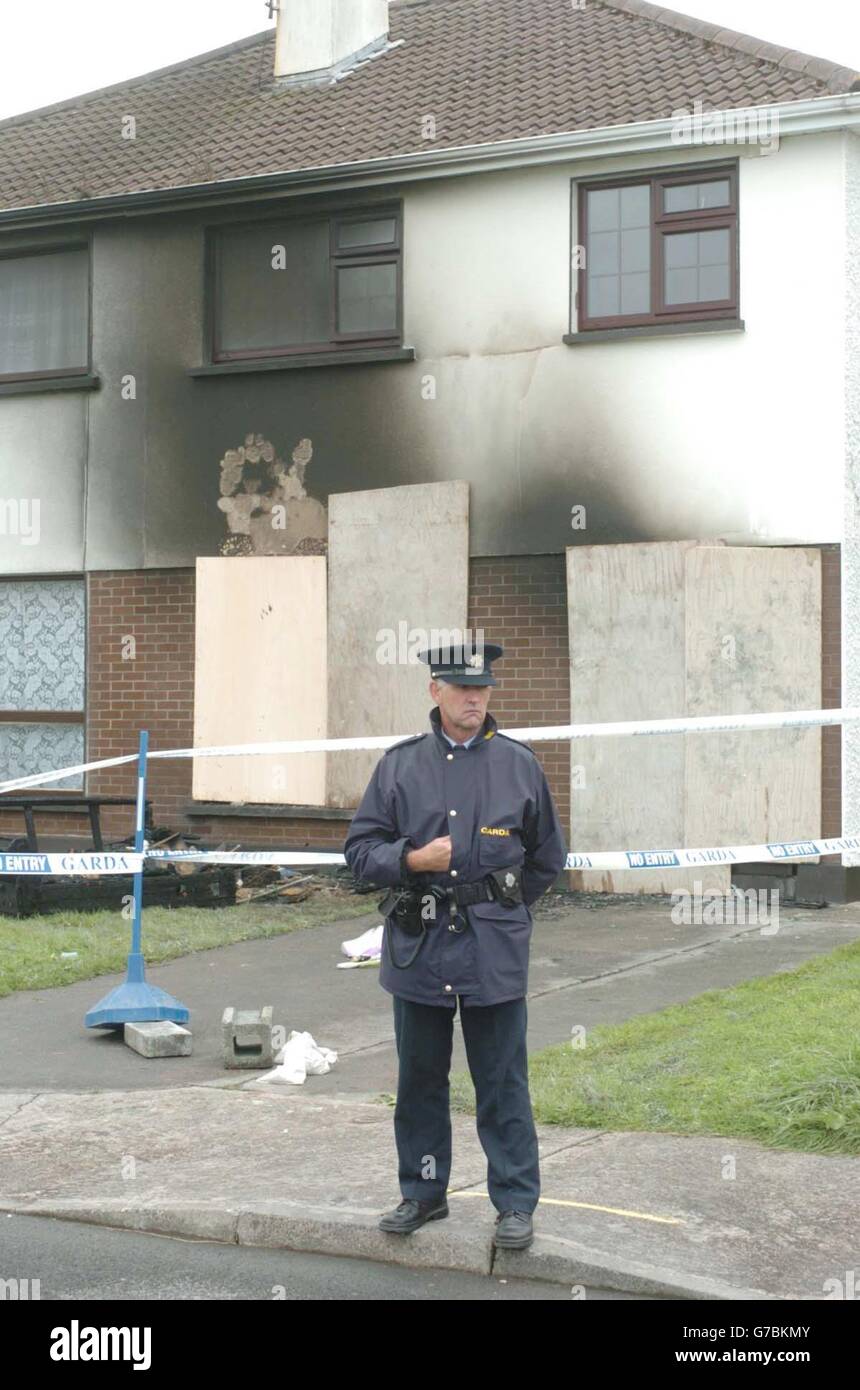 A Garda se tient à l'extérieur de la maison à Castlebar, Co Mayo, Irlande dans laquelle un père et une jeune fille sont morts. L'homme a réussi à porter une fille en sécurité alors que les flammes brûlent dans la maison de deux étages juste après minuit, mais s'est effondré dans la maison en feu pour sauver son autre fille de sa chambre. Banque D'Images